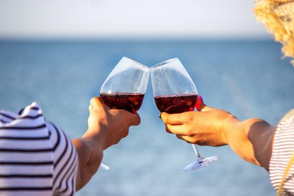 Romantic couple enjoying wine by the sea